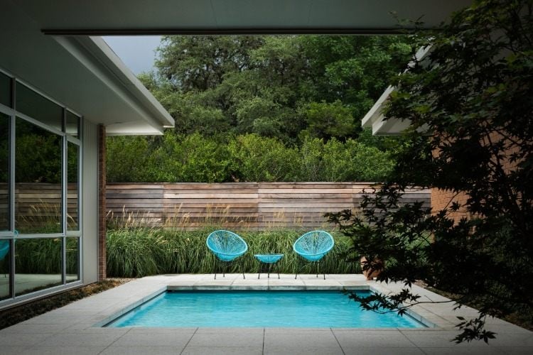 gemütlicher innenhof mit sichtschutz und mini pool im garten gestaltet mit betonblöcken neben dem haus