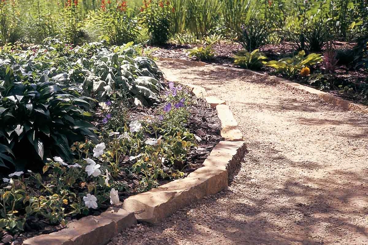 günstiger gartenweg mit kies und naturstein beetabgrenzung