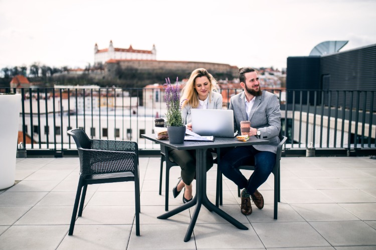 junge geschäftsleute sitzen auf befliester terrasse mit fliesen betonoptik draußen