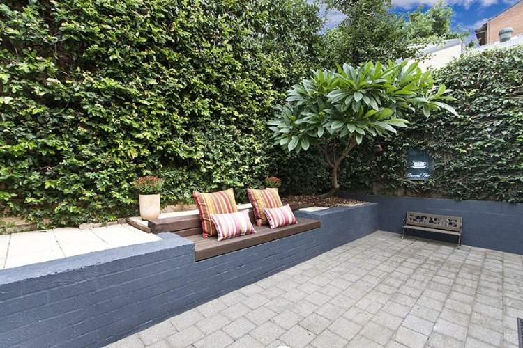 praktische raumgestaltung für terrasse im innenhof mit bank und pflastersteinen