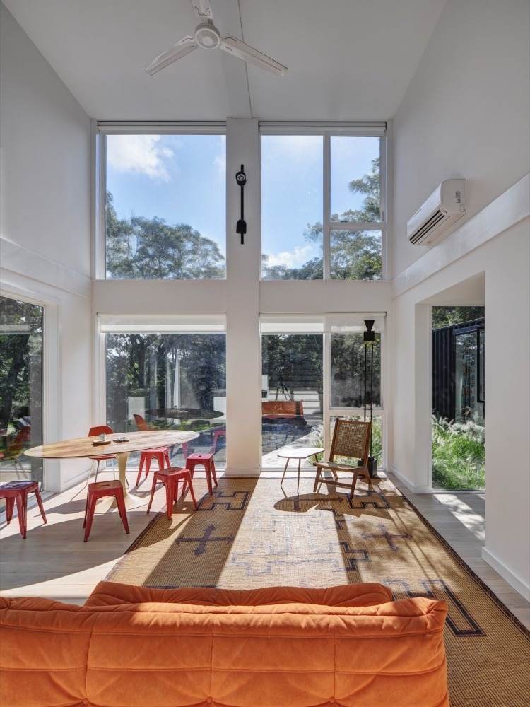 raumnutzung mit hohen decken im innenraum mit minimalistischem design orangem sofa und holztisch