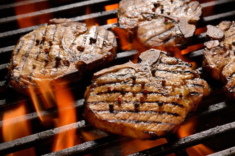 schweinefleisch steaks gegrillt auf grillrost unter feuer