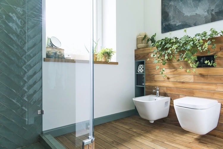 Badezimmer-Dekoration-mit-Efeu-und-Rattan-Windlicht-auf-dem-Regal-hinter-WC-und-Bidet