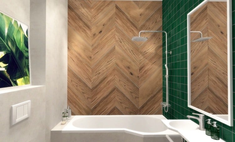 Badezimmer mit smaragdgrünen Fliesen hinter Waschbecken und Wandgestaltung in Holzoptik neben Badewanne