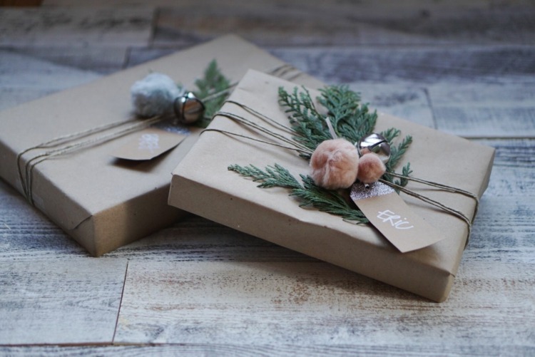 Basteln mit Bommeln und Immergrün für weihnachtliche Dekorationen auf den Geschenken