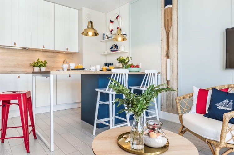 Ikea Küche mit weißen Fronten und Holz Rückwand mit dunkelblauer Insel kombiniert für schönen Marine-Look