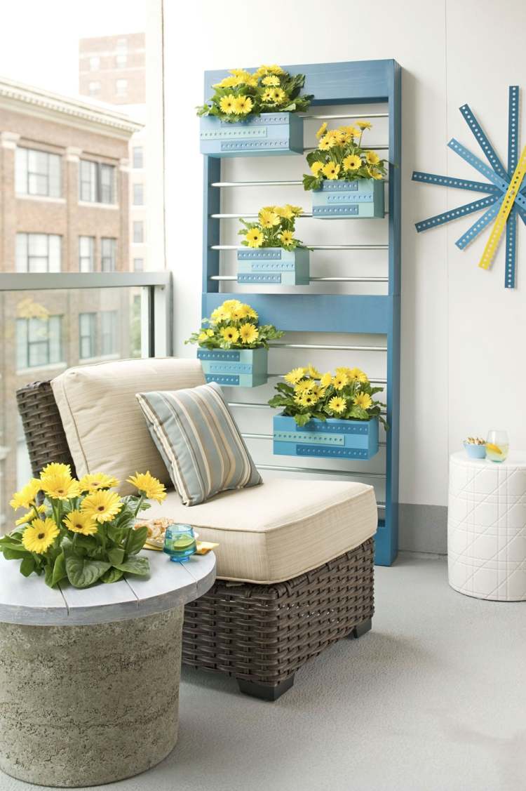 Schickes Gerüst in Blau mit Stangen zum Aufhängen von Blumenkästen mit gelben Blumen