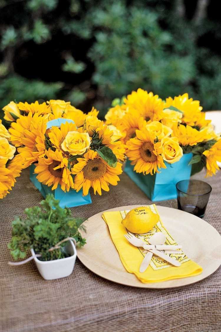 Sommerdeko mit Sonnenblumen und Zitronen für den Tisch