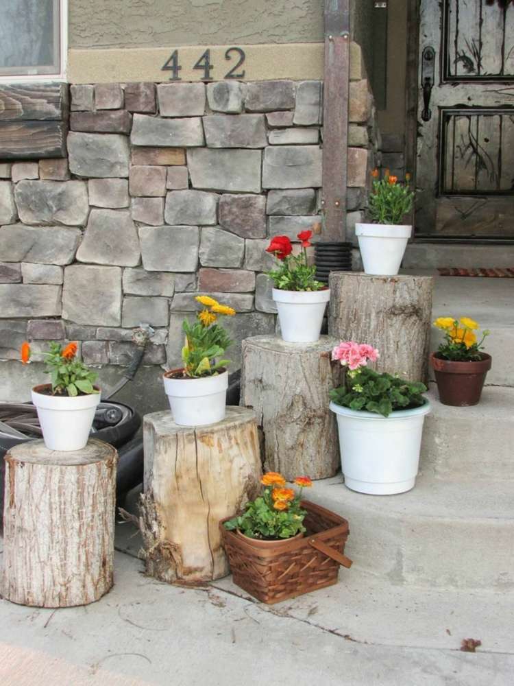 Treppen vor dem Hauseingang mit Baumstümpfen und Blumentöpfen gestalten