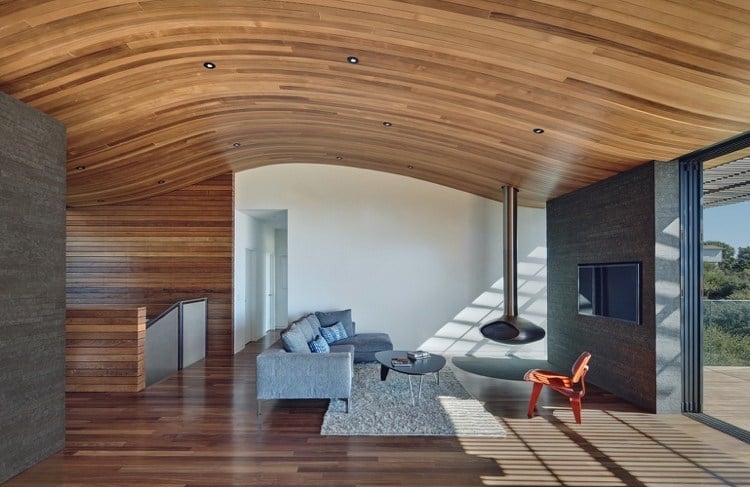 Wohnzimmer mit Holzdecke und Natursteinwand und Kaminofen hängend