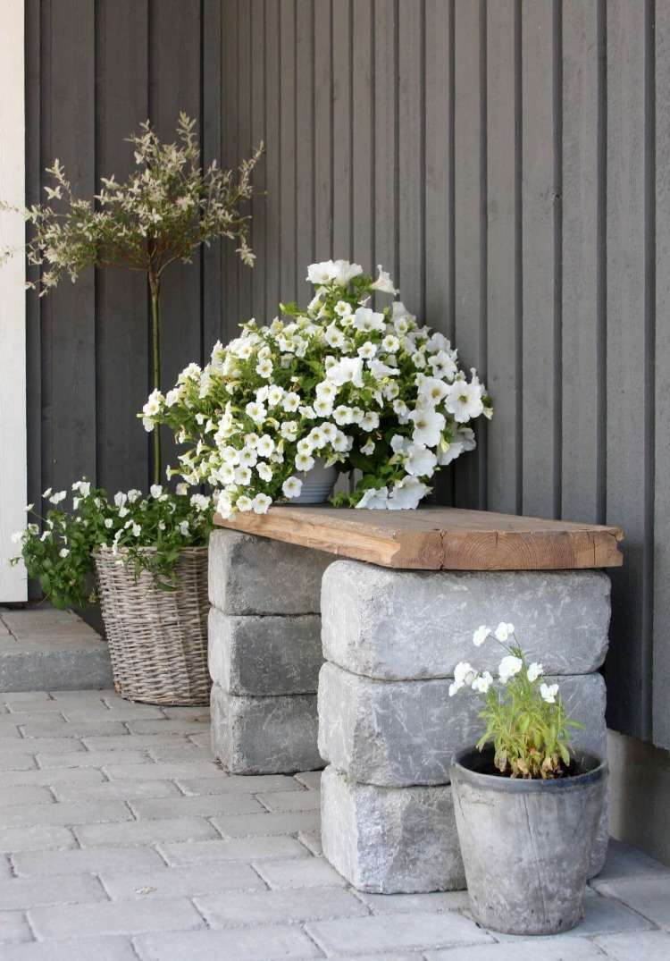 Design old concrete blocks and wood as materials for a bench in the garden with flowers