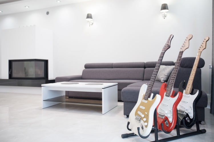 elektrische gitarren auf gitarrenständer in großem wohnzimmer mit minimalistischem design