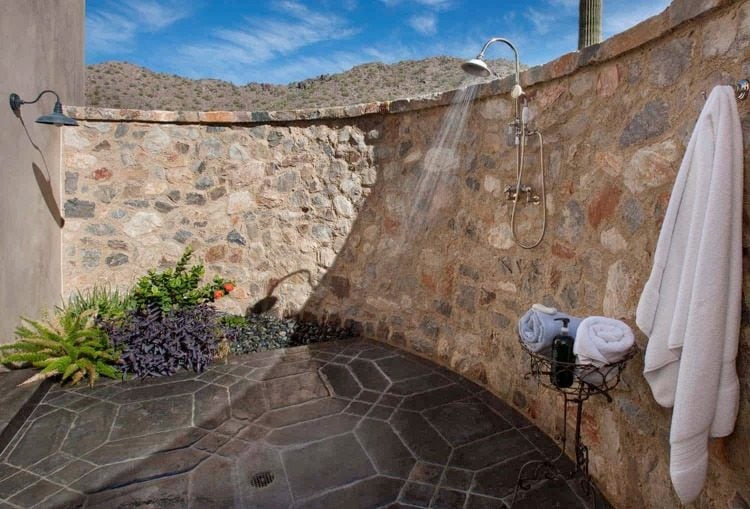 gewölbte steinwand und rustikal verlegter boden im duschbereich mit mediterranem design