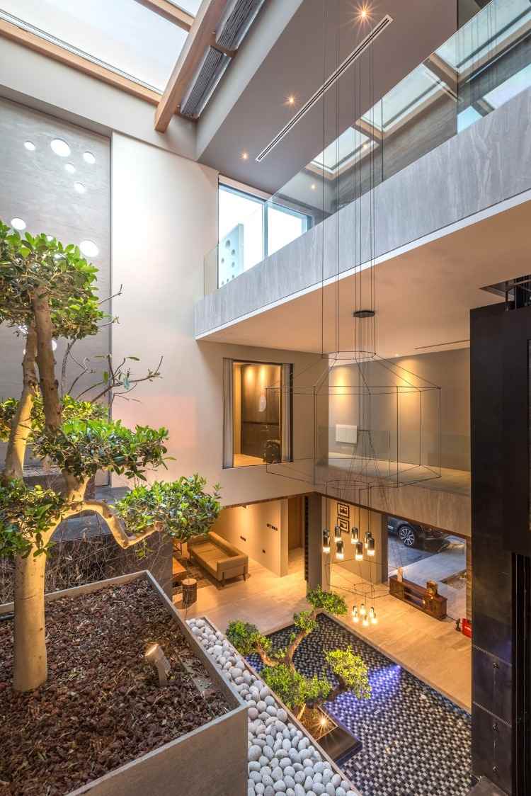 hohe decken und bonsai baum in kombination mit kronleuchter mit biophilic design