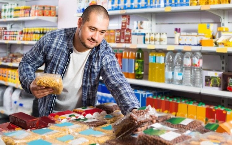 mann im supermarkt bei auswahl an produkten zur produktion von butyrat aus resistenter stärke