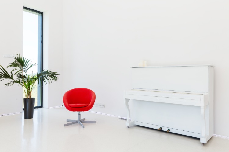 minimalistisches musikzimmer einrichten mit weißem klavier und rotem drehstuhl kontrastierende einrichtungsgegenstände