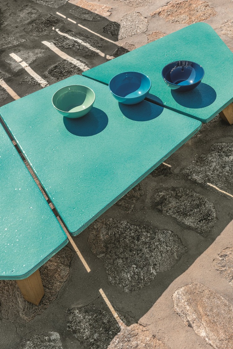 niedriger tisch mit grünen platten und modernen formen auf steinboden