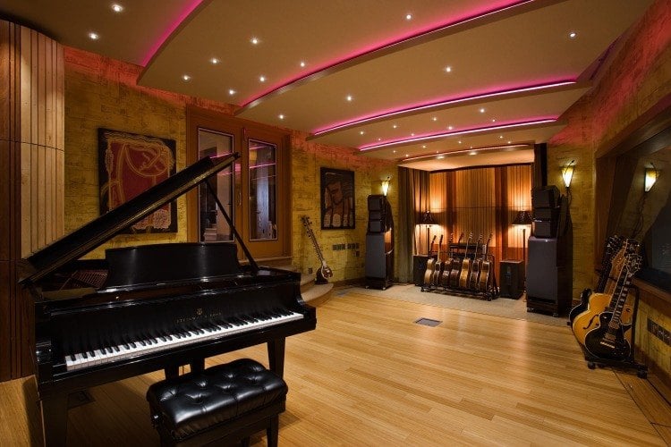 schwarz lackierter klavier im musikzimmer einruchten mit gitarren und anderen musikinstrumenten laminatboden als schallreflexion