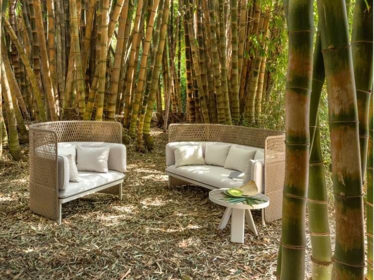 vom bambus umgebene mediterrane gartenmöbel aus gestrickten materialien und kissen