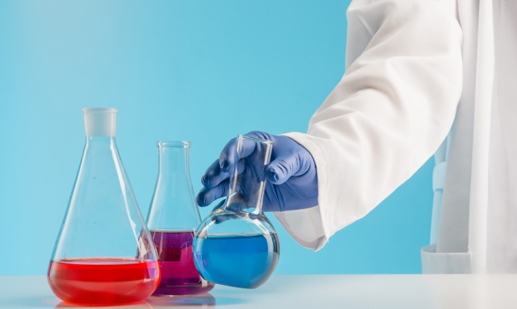 wissenschaftler im labor untersucht farbige flüssigkeiten mit gummihandschuhen