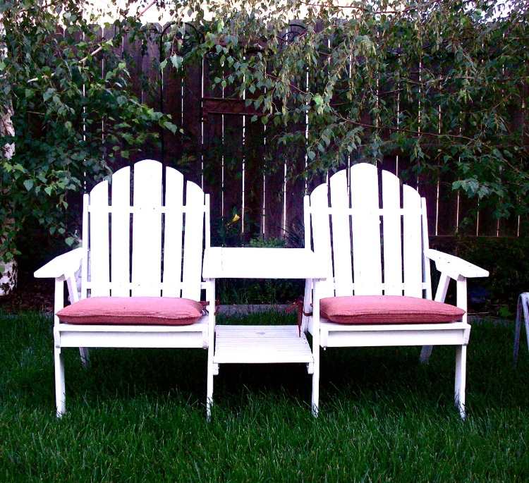 use two interconnected white chairs outside as a garden bench