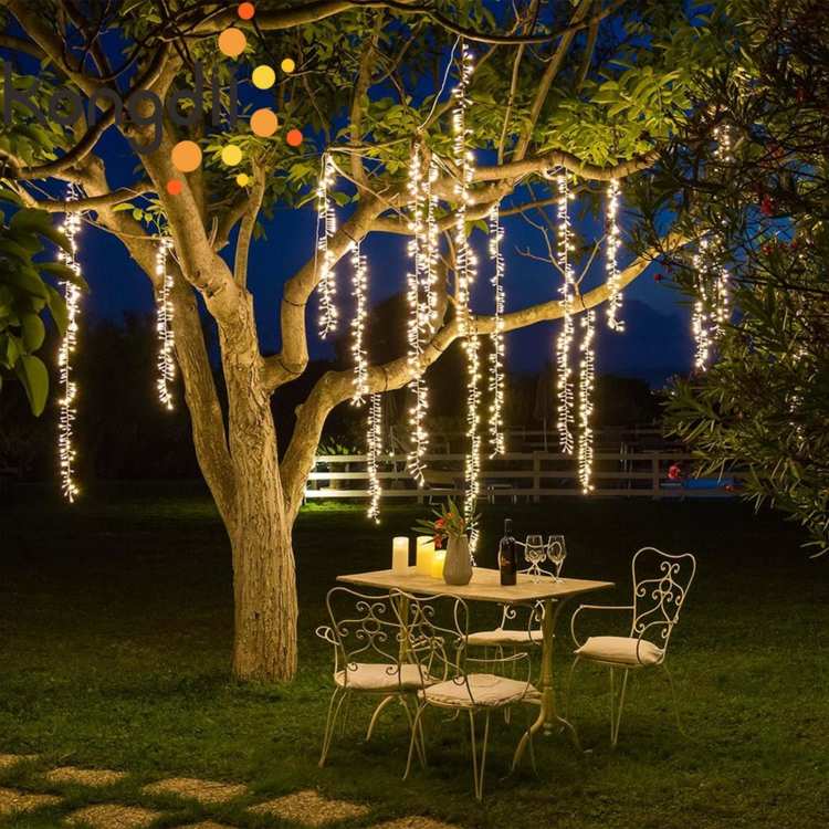 Baum dekorieren im Garten mit hängenden Lichterketten über einem Tisch