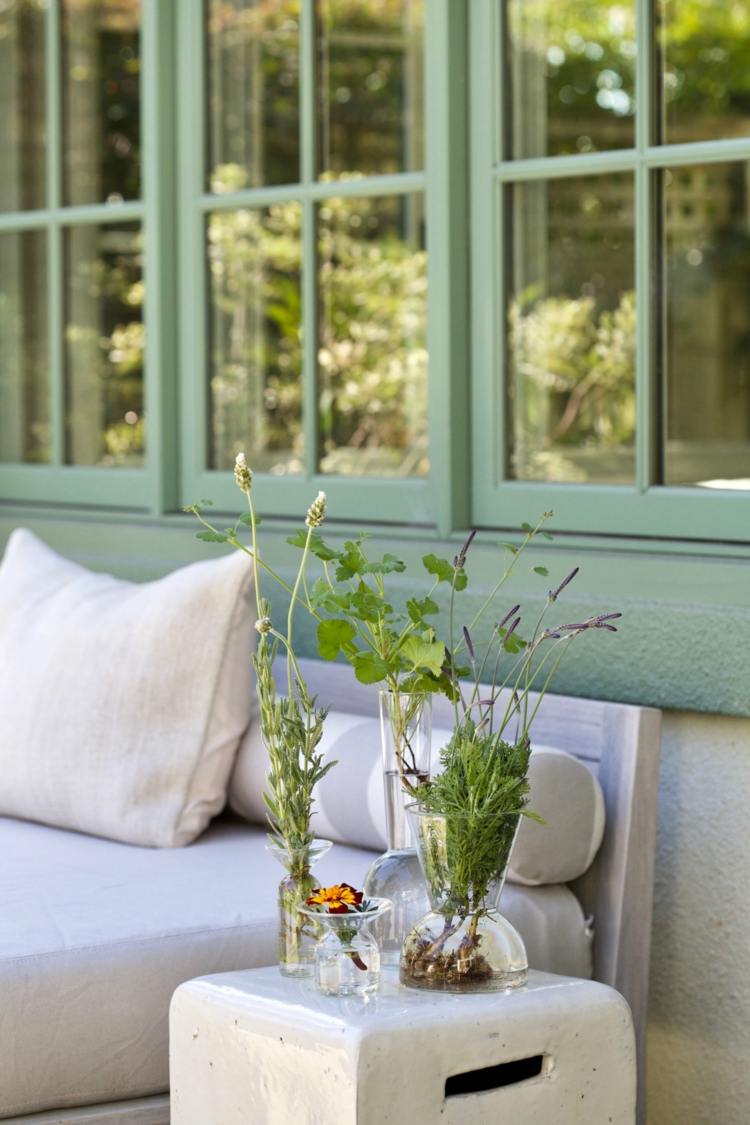 Beistelltisch auf der Terrasse dekorieren mit Geranien, Lavendel und Ringelblume im Glas
