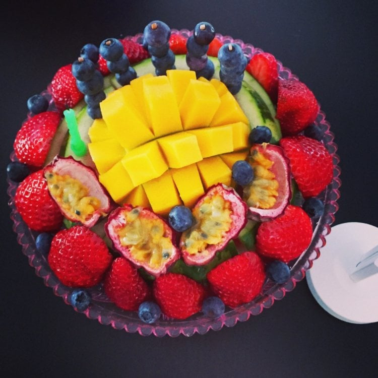 Kleiner Früchte-Kuchen mit Mango, Feigen, Blaubeeren, Erdbeeren und Kerzen