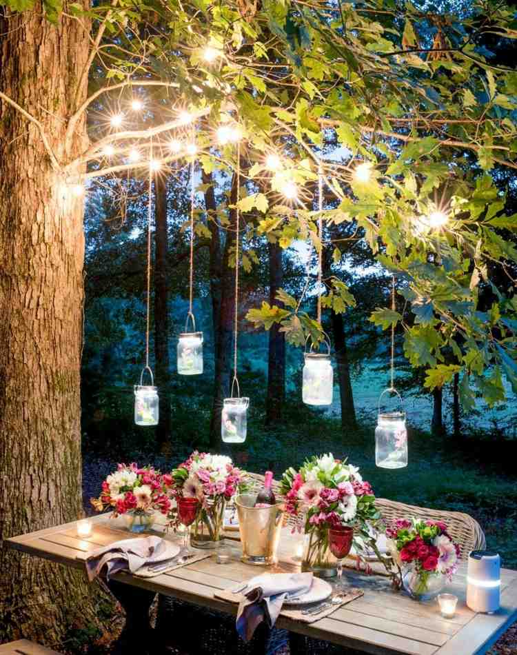 Schöne Garten-Idee mit Einweckgläsern und Lichterketten über einem Esstisch
