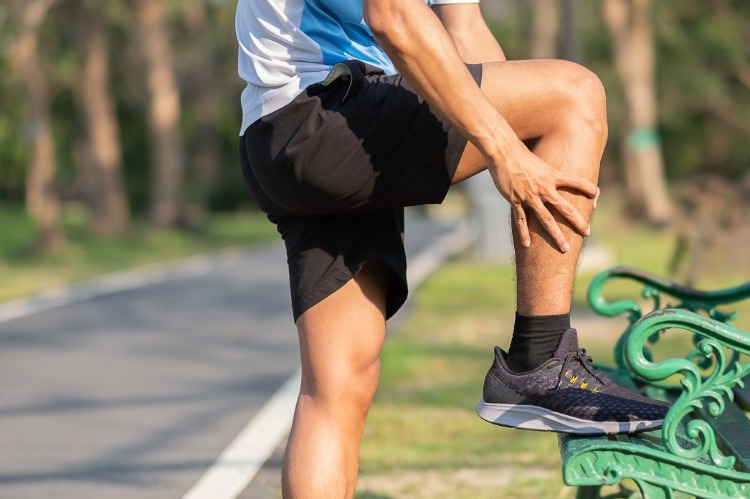 mann hält sein bein wegen verletzung des muskels im park