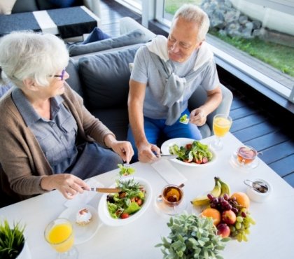 älteres paar im restaurant mit pflanzlichen lebensmitteln gesunde alterung mit diät