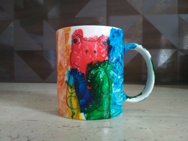 Bemalte Tassen mit bunten Farben und Frosch