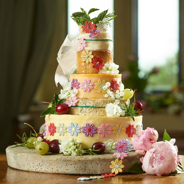 Bunte Käse Hochzeitstorte mit Blüten aus Spitze und Früchten