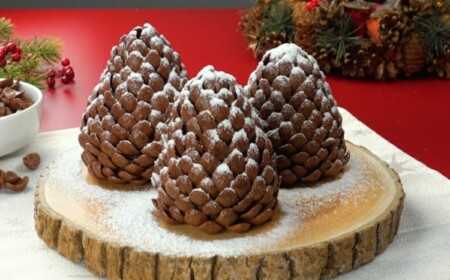 Essbare Winterdeko auf einer Holzscheibe - Zapfen mit Paste aus Erdnussbutter