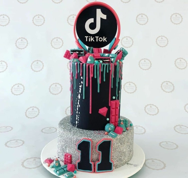Large TikTok cake on two levels with a silver base and drops