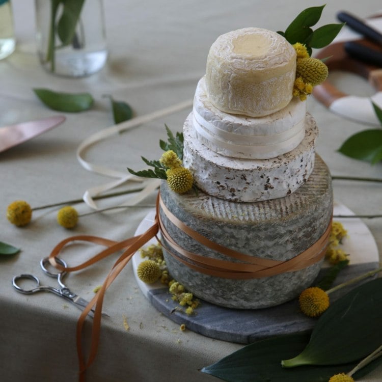 Autumnal cheese wedding cake with dried yellow flowers and ribbons