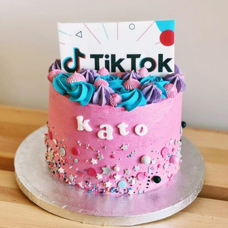Nicely decorated cake in pink with stars, balls and pearls