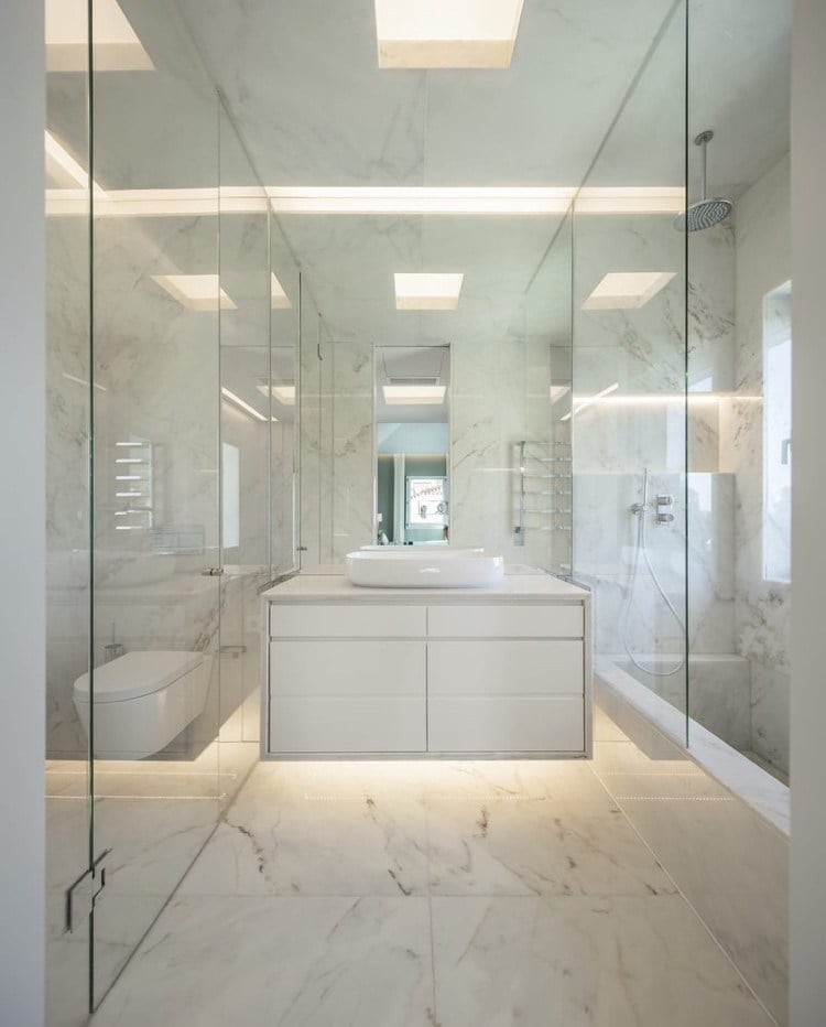 Modernes weißes Badezimmer mit Hängeschrank und Badewanne und Regendusche und großformatigen Marmorfliesen