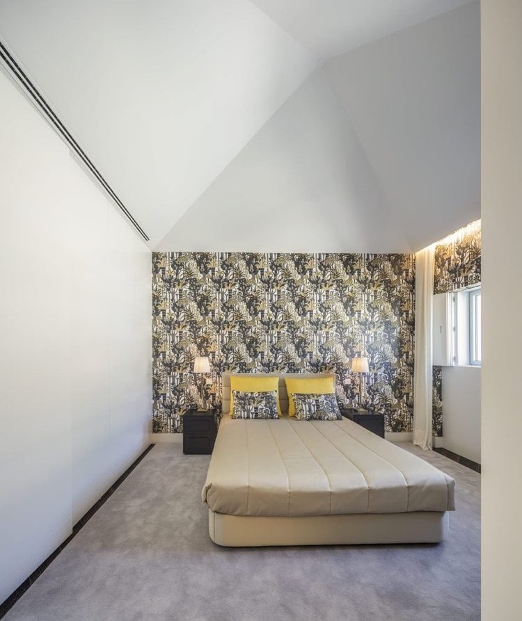 Schlafzimmer mit Dachschräge und Tapeten an der Wand