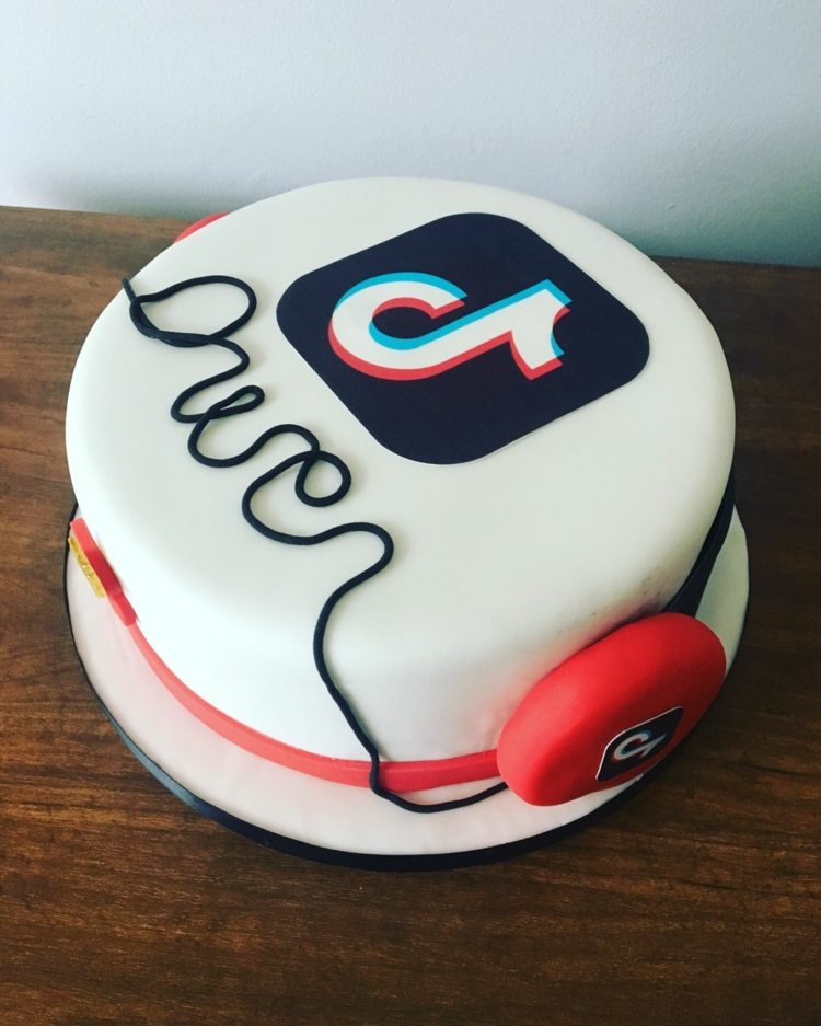 Simple TikTok cake in white with logo and headphones with cable as lettering