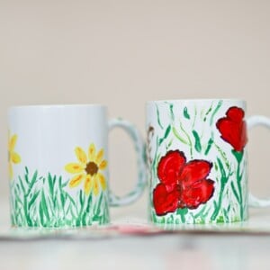 Tassen bemalen mit Kinder mit gelben und roten Blumen und Gras