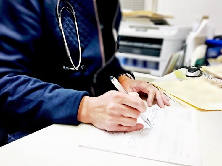 doctor prescribes antihypertensive medication on desk