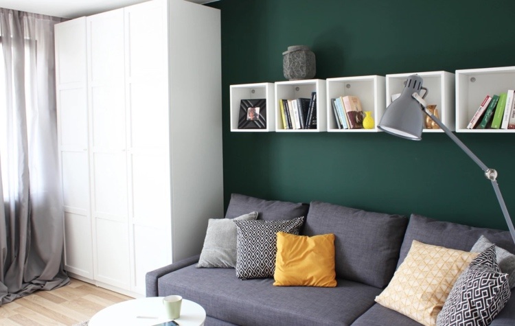 dark green wall living room behind gray sofa