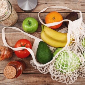 obst und gemüse sowie vollkornprodukte mit ballaststoffen und vitaminen für gesunde ernährung in einem netzbeutel