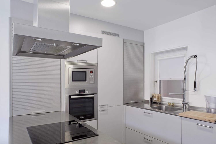 Aluminum roller shutters in the kitchen go well with stainless steel appliances and gray countertops