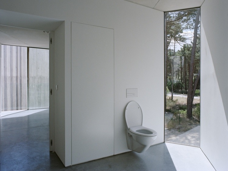 Brutalistische Innenarchitektur mit Toilette mit Fenster