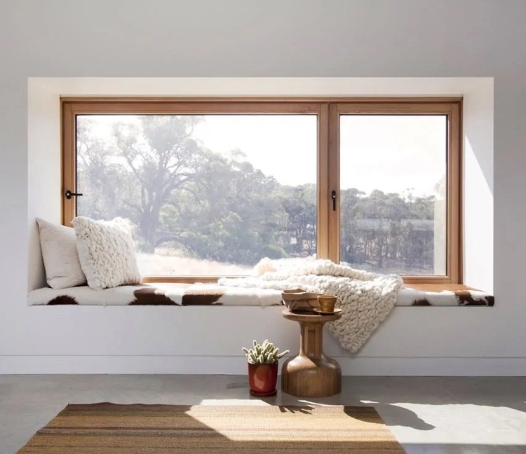 Erkerfenster bauen und Sitzplatz arrangieren mit kuscheliger Decke und Sitzkissen und Kaffeetisch