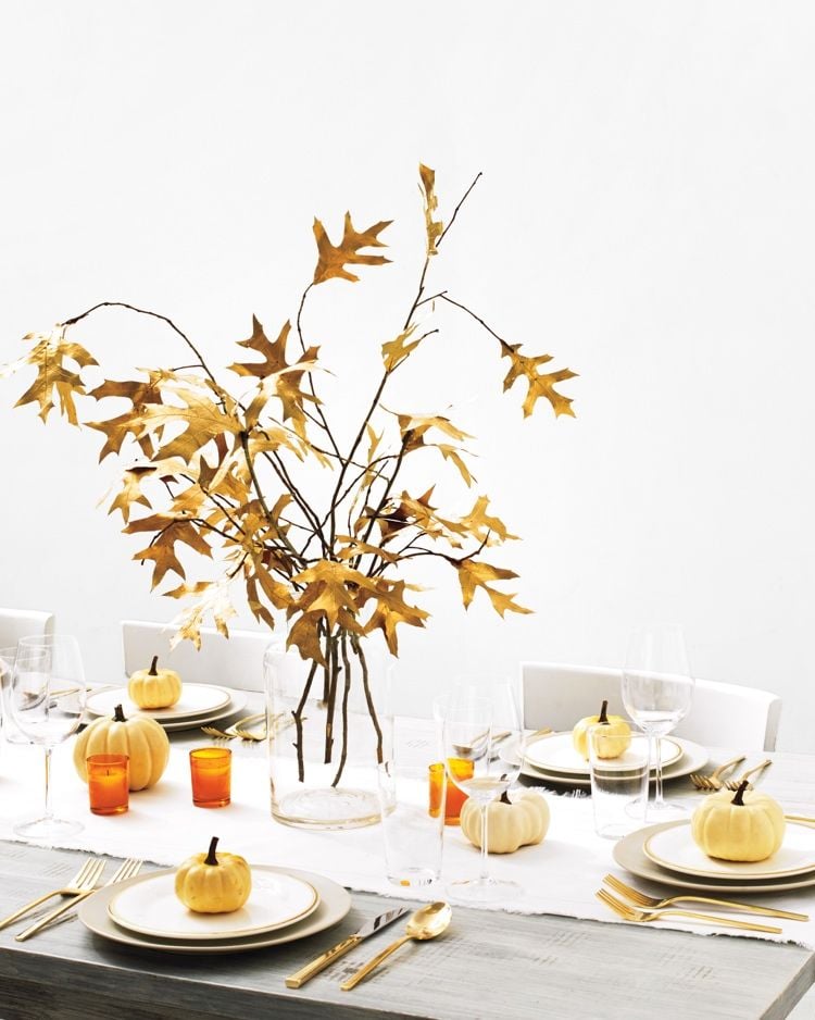 Herbstdeko Tisch modern mit Herbstblättern und Kürbissen und goldenem Besteck