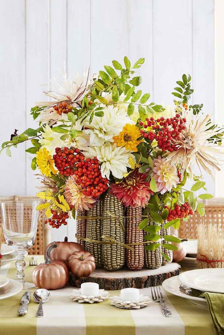 Herbstdeko mit bemaltem Mais und Hagebutte und frischen Blumen
