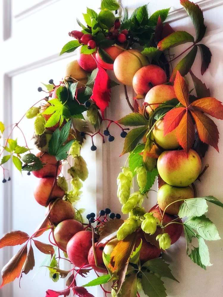 Autumn wreath for the door made of apples, hops and wild wine